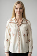 Mujer con blusa beige de bordados étnicos en hombros y manga larga, vista frontal de estudio