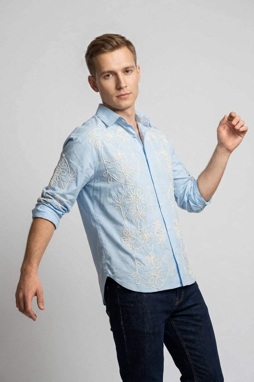 Modelo con camisa azul bordada de manga larga, silueta completa en estudio