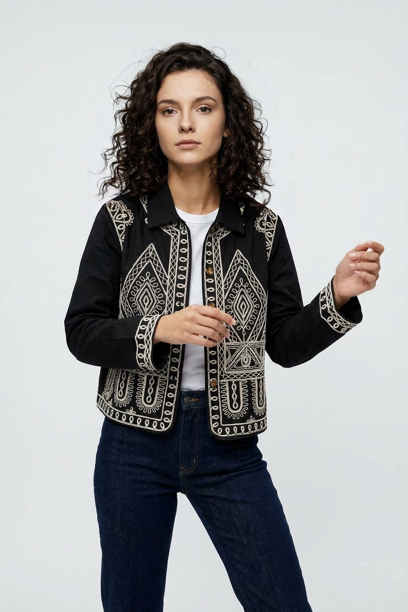Mujer con sobrecamisa negra bordado geométrico blanco, vista frontal completa de estudio