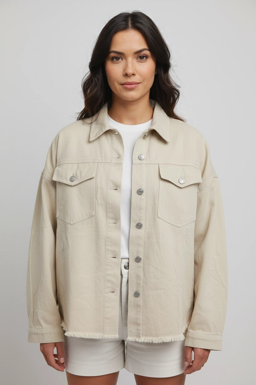 Mujer con chaqueta beige oversize abierta, bolsillos con tapa y botones plateados, vista frontal de estudio