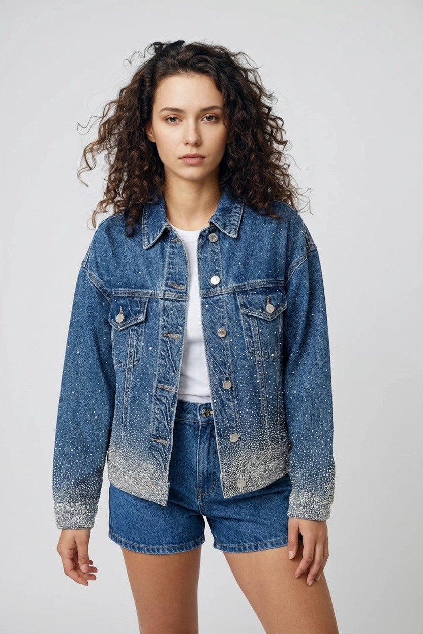 Modelo con chaqueta vaquera brillante azul y shorts denim, look total denim con destellos, vista frontal