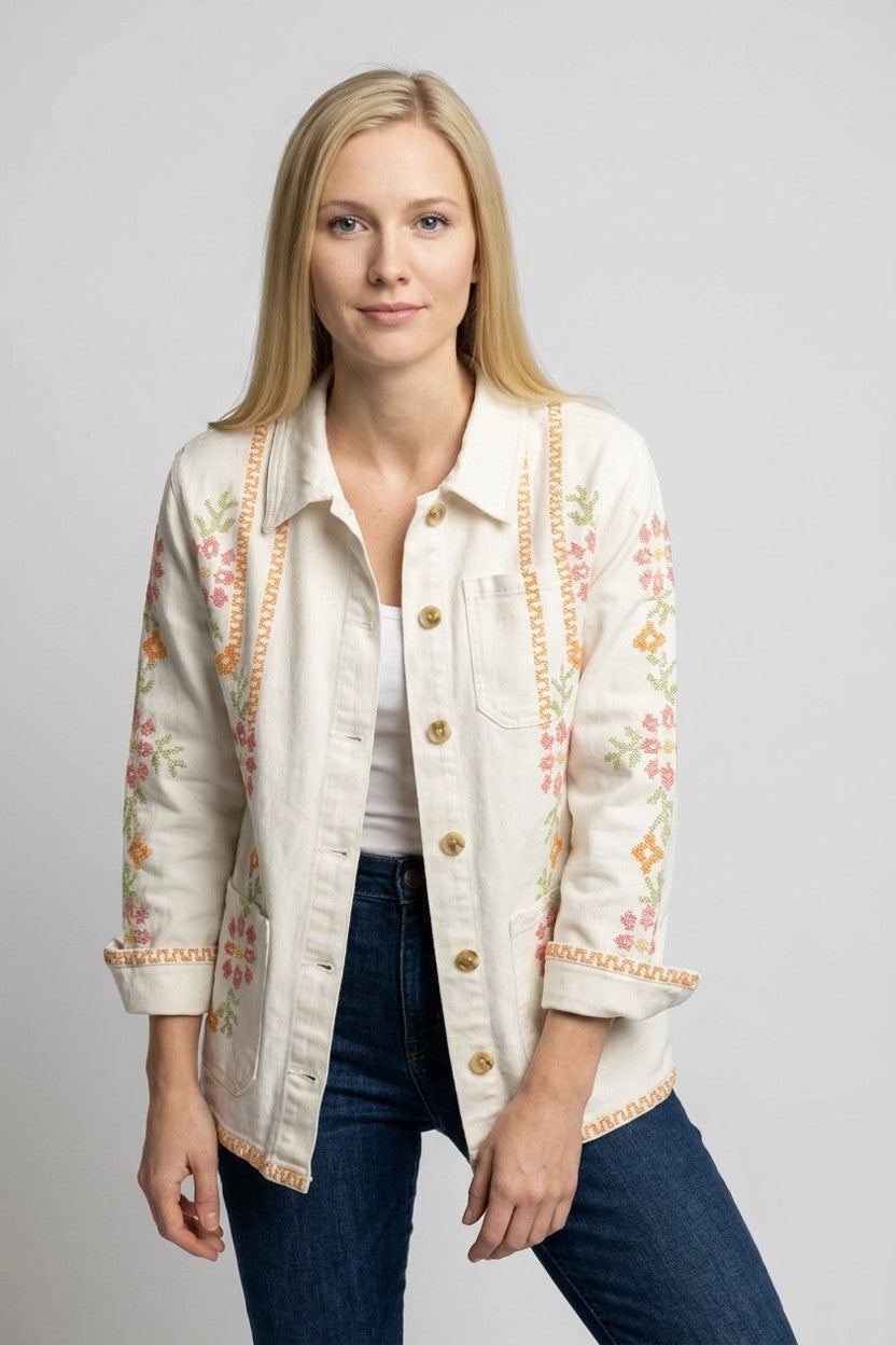 Mujer con chaqueta blanca punto de cruz abierta sobre camiseta blanca y vaqueros, vista frontal entera en estudio