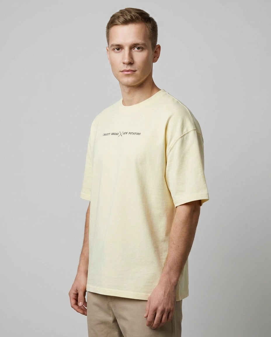 Hombre con camiseta oversize cruda, vista lateral de estudio mostrando silueta holgada