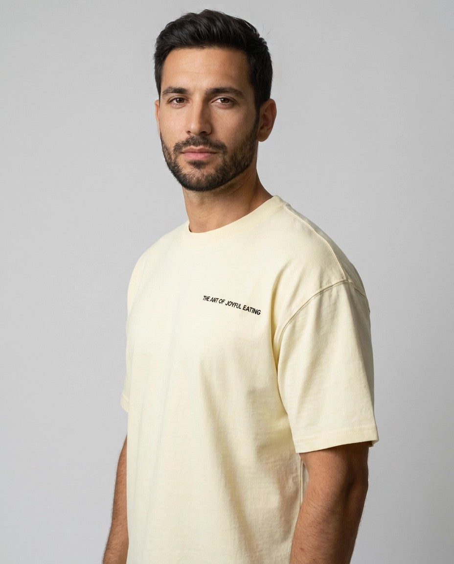 Hombre con camiseta oversize cruda Feast Mode On, plano medio lateral
