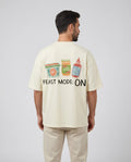 Detalle del estampado Feast Mode On en camiseta oversize cruda