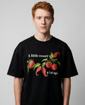Hombre con camiseta negra oversize y estampado sweet & spicy, vista frontal de estudio